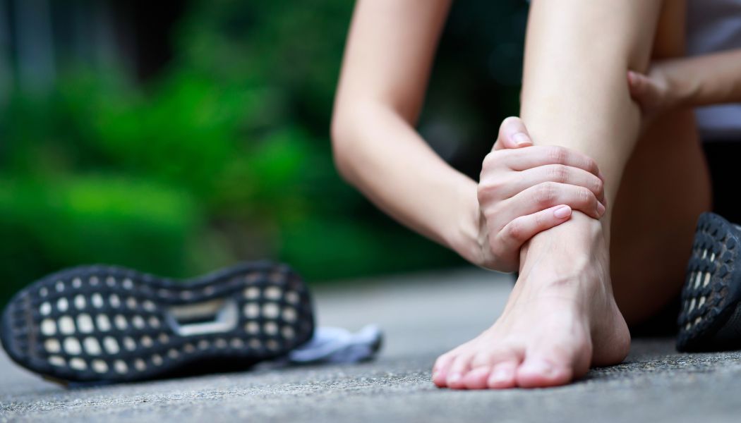 Person greift sich ans Sprunggelenk nach dem Sport – mögliches Zeichen aktiver Triggerpunkte